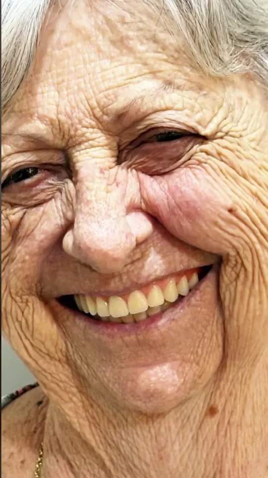 Dona Emília, paciente da Clínica Dentista da Família, sorrindo em depoimento.